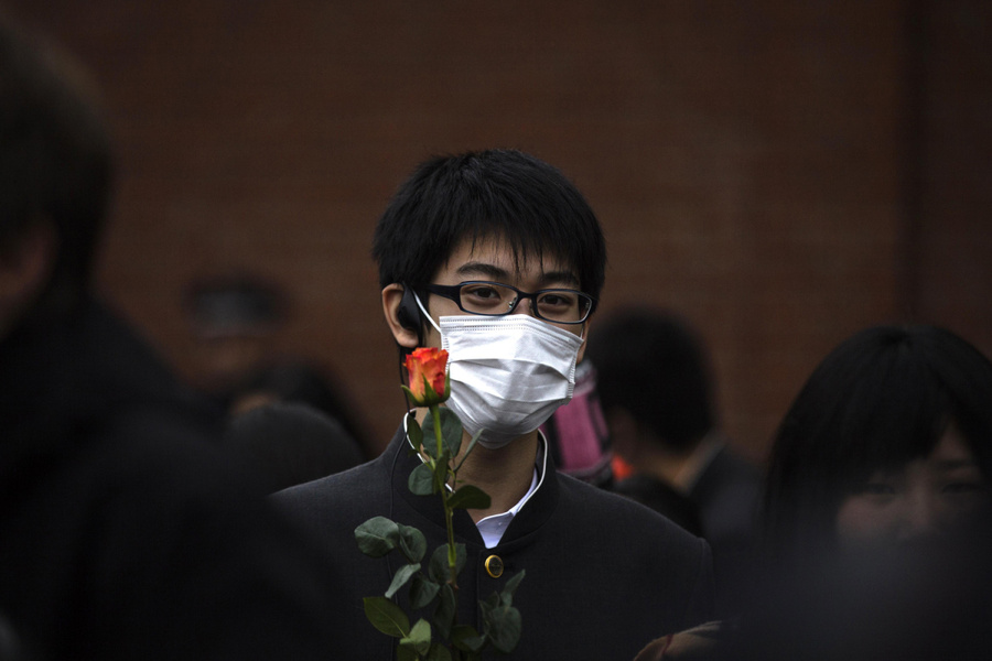 2012年11月9日，在柏林Bernauer Strasse遗址地，一名日本高中生手拿一支玫瑰参加纪念.jpg