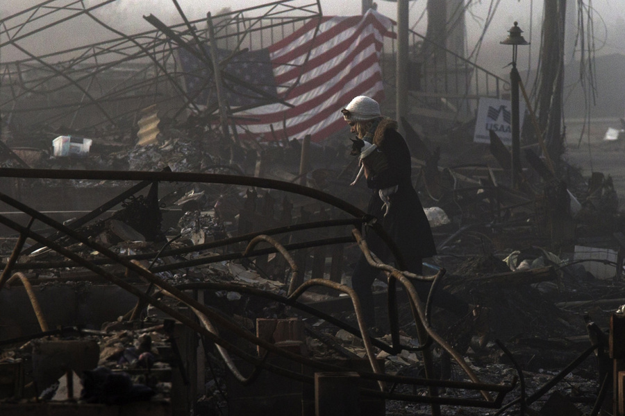 2012年11月12日，纽约州皇后区一片飓风“桑迪”肆虐后留下的废墟中，一名女子搂着她的.jpg