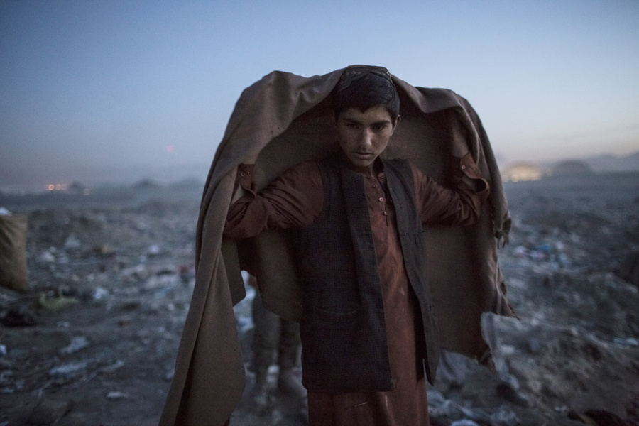 2012年11月14日，阿富汗喀布尔一名普什图族男孩在捡了一天垃圾后准备收工，他说自己由.jpg