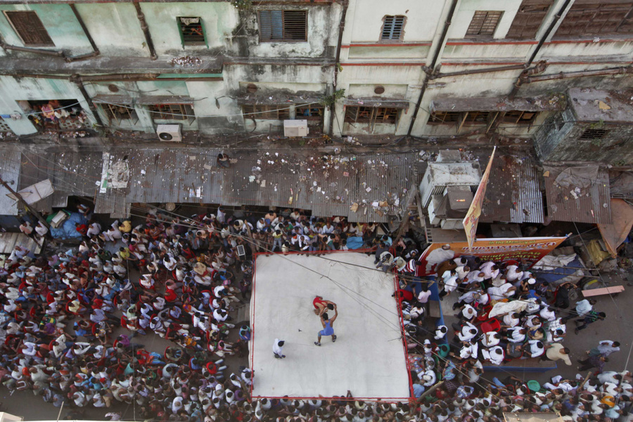 2012年11月14日，印度加尔各答，两个摔跤手在一个路口的临时拳击场上进行一场业余摔跤.jpg